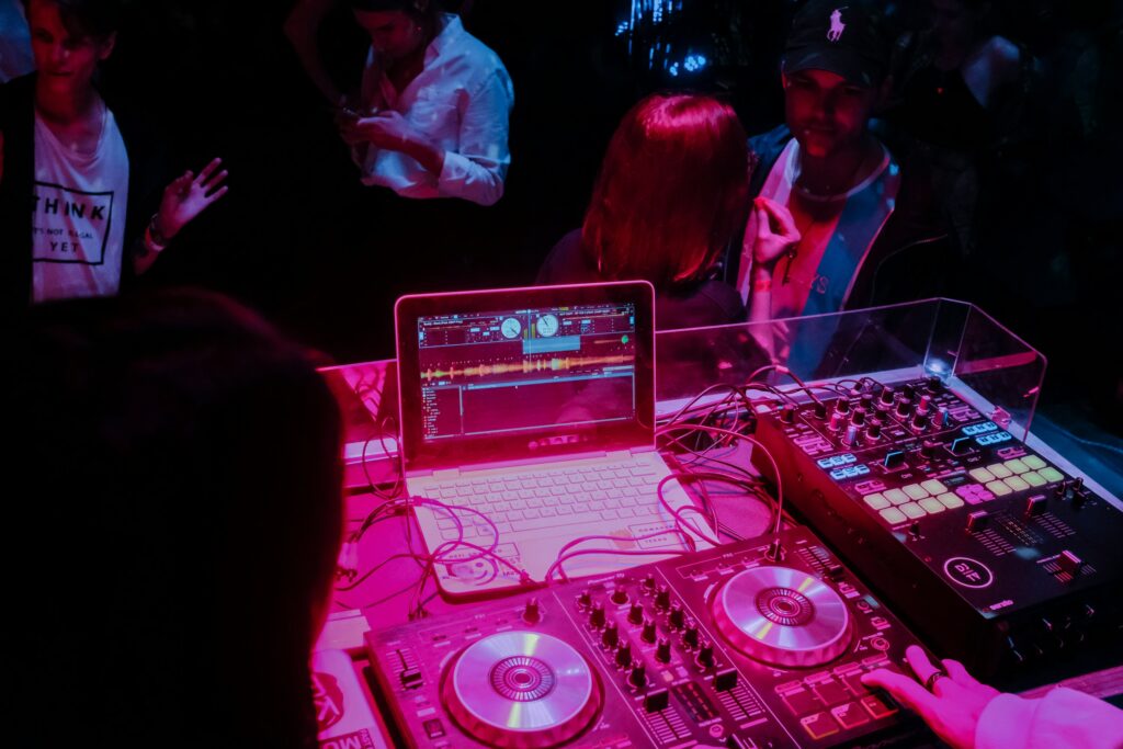 A DJ spins tracks for a club with several individuals reacting differently to the event entertainment. Utilizing DJ tools to guide playlists.