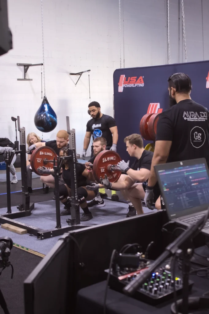 A USAPL Reunited Open athlete attempts the squat movement.